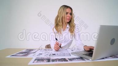 女建筑师在她的办公室工作，从事新的项目；手工图纸，计算机图纸。